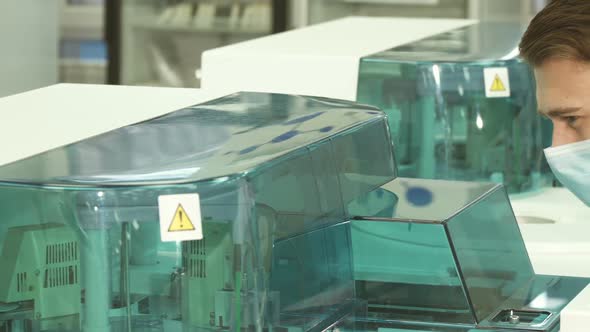 Lovely Laboratory Assistant Looks Closely at the Work of the Laboratory Centrifuge