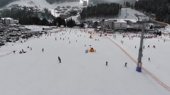 Aerial View on Lot of People Skiing on Ski Slopes Near Ski Lifts on Ski Resort