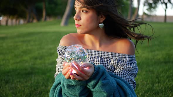 A beautiful sorceress holding a magic glowing crystal ball with an enchanting and mysterious look.