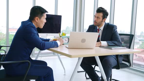 Two Business People Talk Project Strategy at Office