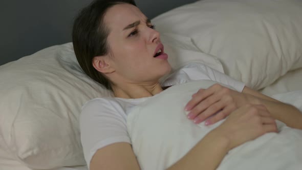 Young Woman Waking Up From Nightmare in Bed 