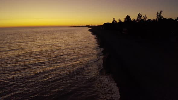 Aerial View Drone Footage Low Flight Over a Deserted Beach at Sunset