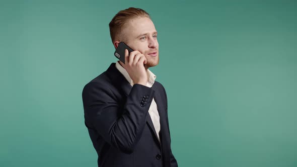 Young Businessman Speaks with Smile on Phone