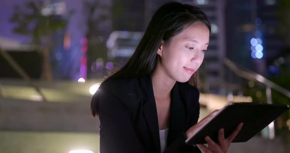 Business woman work on tablet computer at night