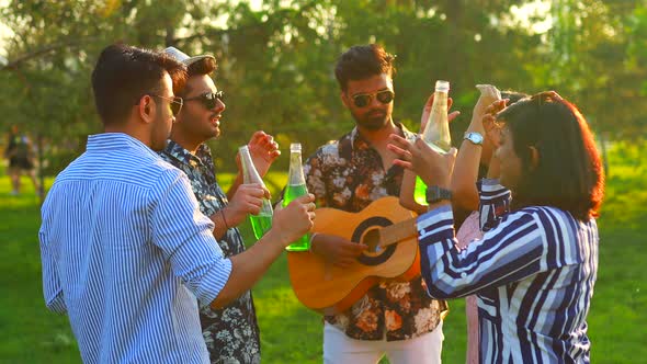 Indian Students Having a Lunch in Delhi Park Outdoors Playing on Guitar  Singing and Dancing