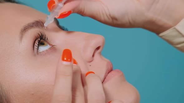 Young Woman with Manicure Drips Special Liquid Into Eye