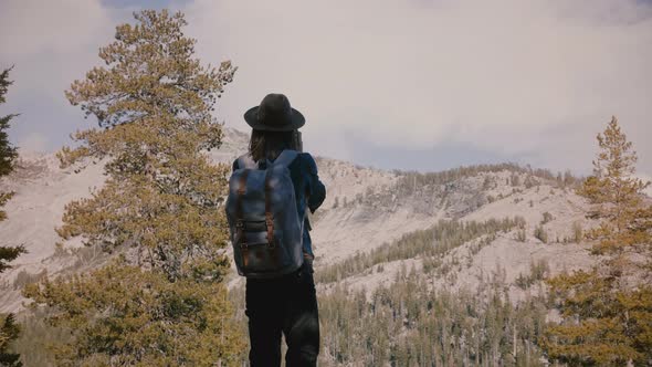 Young Beautiful Tourist Girl with Backpack Takes Photos of Amazing White Rocks at Yosemite National