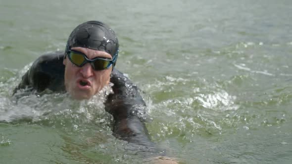 Professional Swimmer Triathlete in a Wetsuit Swims in Open Water an Athlete Trains Before a