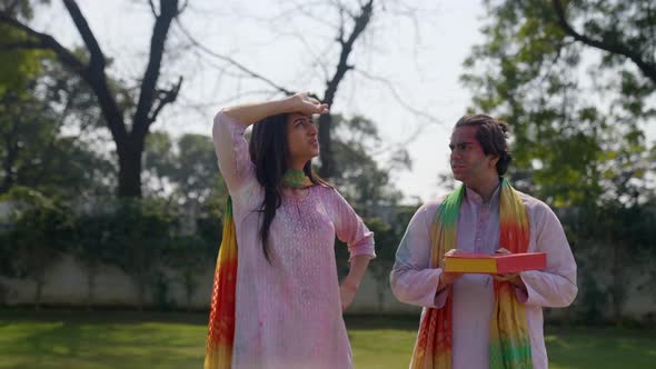 Cute Indian couple talking at a Holi festival