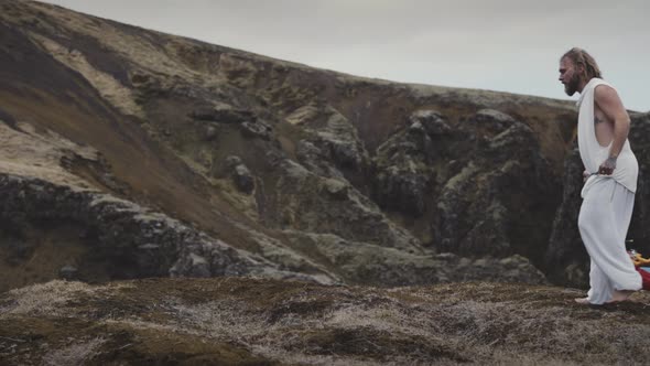 Curly Hair Man Walking Towards The Mountain Drags A Piece Of Thin Fabric