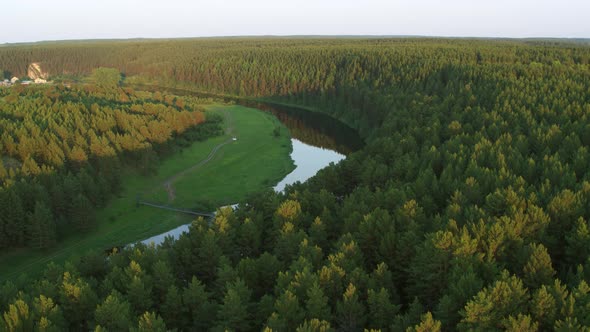 Aerial View of the River with a Rock and Forest on the Banks