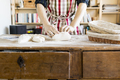 Midsection baker kneading dough at table in bakery - PhotoDune Item for Sale