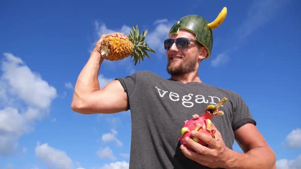 Vegan Power Healthy Lifestyle Concept. Athletic Man With Fruits Against Blue Sky