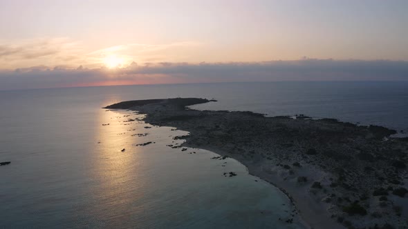 Aerial view of Elafonisi Beach at Sunrise. Flying above Sea in Greece. Golden hour above Island 