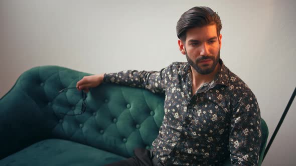 Stylish Elegant Latin American Handsome Man Sitting on the Sofa Indoors Studio Shot