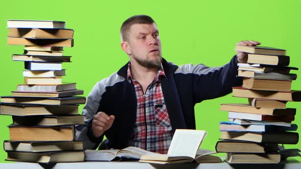 Man Chooses the Most Interesting Book, and Writes in a Notebook. Green Screen