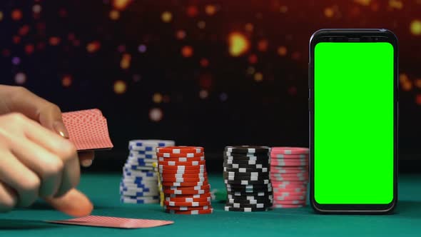 Female Croupier Dealing Cards Near Stacks of Chips and Green Screen Smartphone