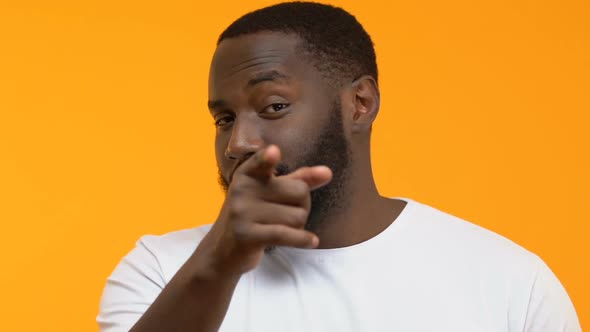 Young Man Pointing in Camera and Showing Mobile Gesture, Asking to Call Back