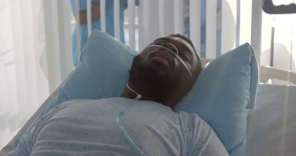 Africanamerican Male Patient with Nasal Cannula Having Fever Lying in Hospital Bed