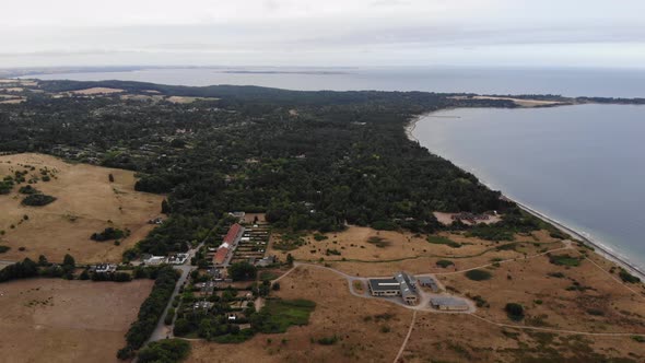 Aerial view of the coastline of Sejerøbugten with hills, fields and ocean.