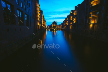 rstadt in twilight. Blue hour. Tourism landmark of Hamburg. View of Wandrahmsfleet in light of lantern lamp in HafenCity.