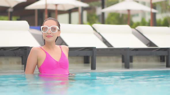 Young asian woman enjoy around outdoor swimming pool for leisure