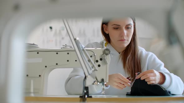 Two Young Dressmaker Working with Fabric in Design Bureau