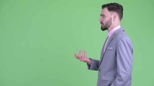 Profile View of Happy Young Bearded Businessman Talking