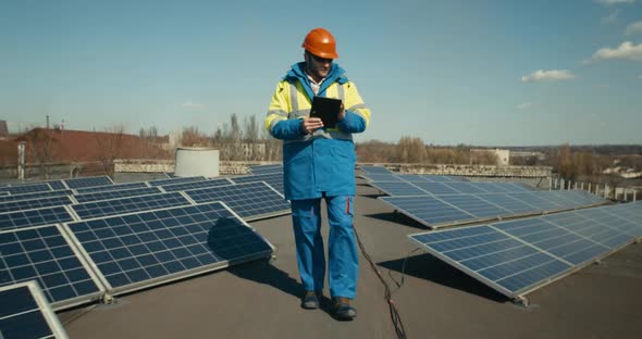 Technician Walking Between Solar Panels