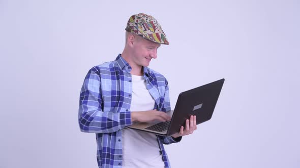 Happy Young Handsome Hipster Man Thinking While Using Laptop