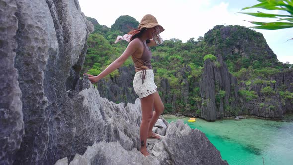 Woman Holding Shawl In Breeze On Limestone Rocks