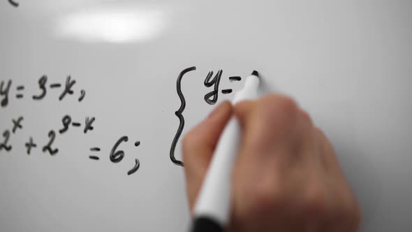 Young Student is Solving Math Equation on Whiteboard Close Up