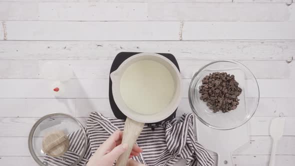 Time lapse. Flat lay. Preparing homemade chocolate ganache for chocolate raspberry cupcakes.