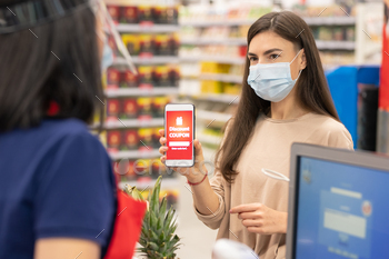 scount coupon on her smartphone in supermarket