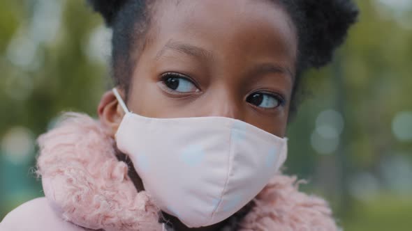 Closeup Cute Little Girl in Mask Outdoors Curly Child Posing in City Park Lockdown Portrait Serious