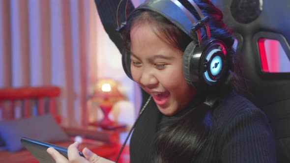 Young Girl Playing A Game Online On Smartphone While Sitting On The Chair And Win alt