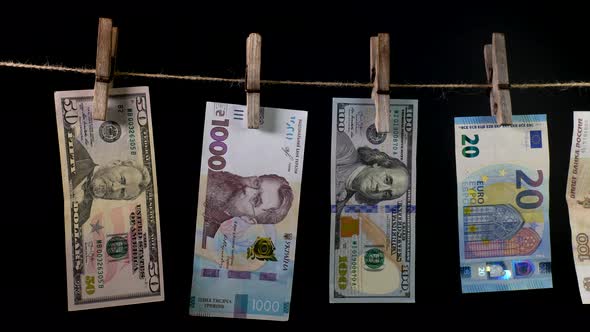 Banknotes of Different Countries Dry on a Clothespin Rope