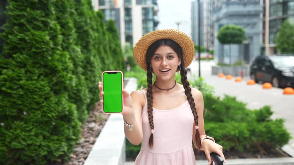 Woman Showing Modern Smartphone with Green Screen for Replacement