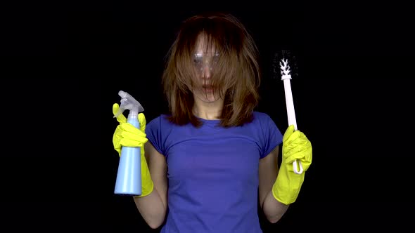 A Young Woman with Tousled Hair Finished Cleaning. Woman in Safety Glasses and Gloves with Tools for