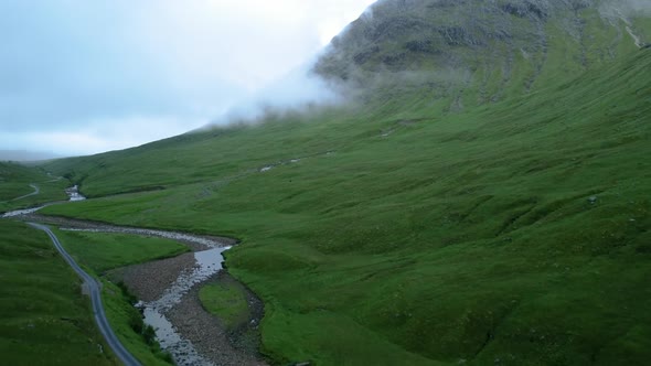 Mountain peak revealed through clouds on country road