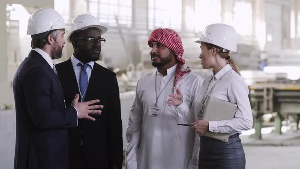 Caucasian factory worker sharing experience with foreign guests