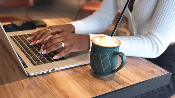 African American Woman Hands in Cafe with Coffee Working on Laptop Typing