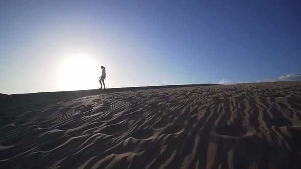 Girl Makes Steps in the Desert at Sunset, Wide Angle, Slow Motion