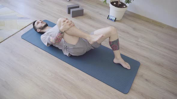 Young Man Deep Breathing on Yoga Mat
