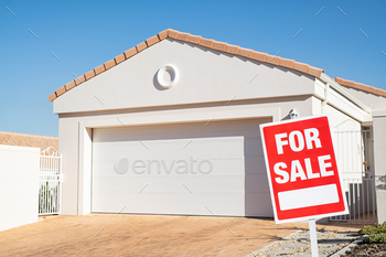 rd outside home in lawn. Real estate board in front of new house for sale with copy space.