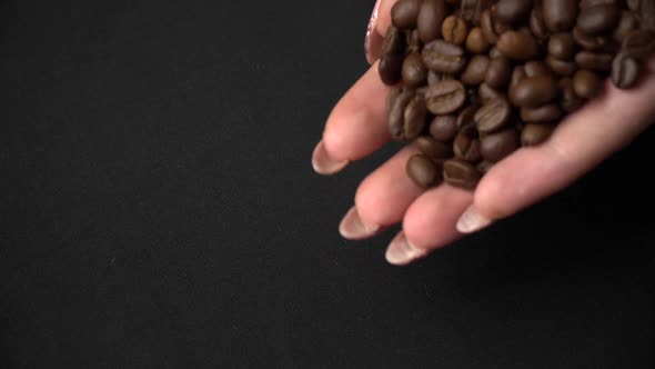 Coffee Beans are Hung Out of Female Hands