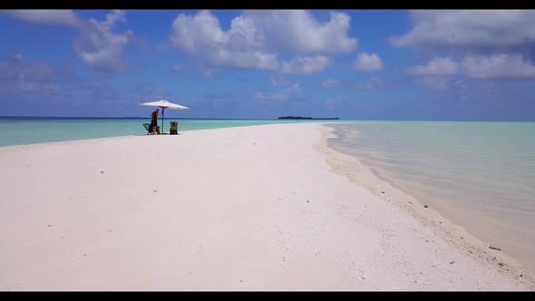 Family of two happy together on marine coast beach holiday by blue lagoon with white sandy backgroun