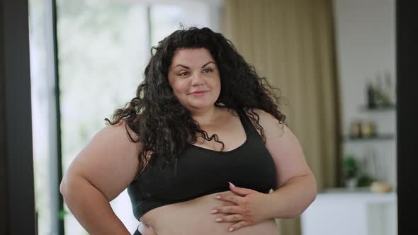 Plussize Woman in Underwear Looks at Mirror Reflection