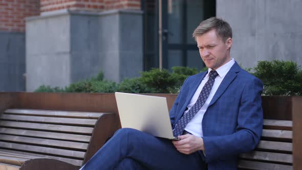 Headache Businessman in Tension Using Laptop in Front of Office