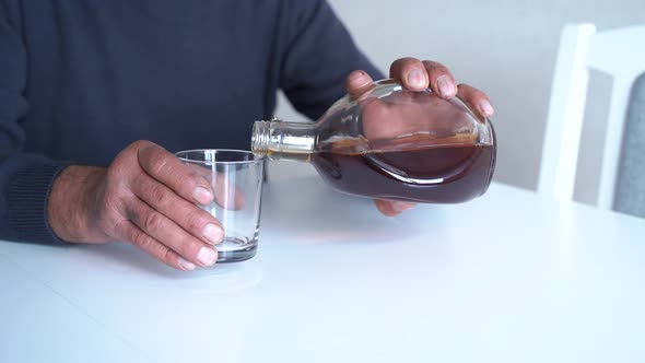 Crop Man Pouring Alcohol Over Table